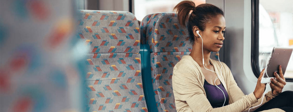 woman riding train on tablet